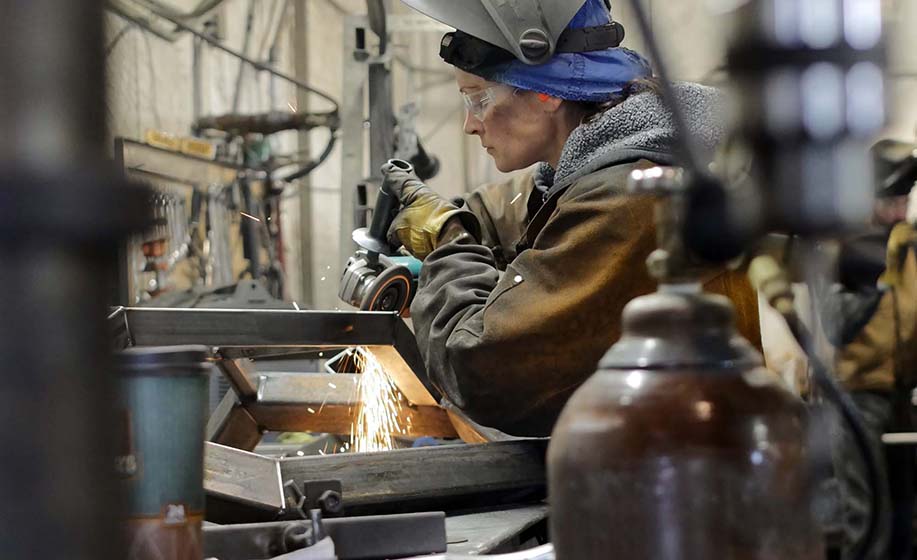 A skilled fabricator finishes welds